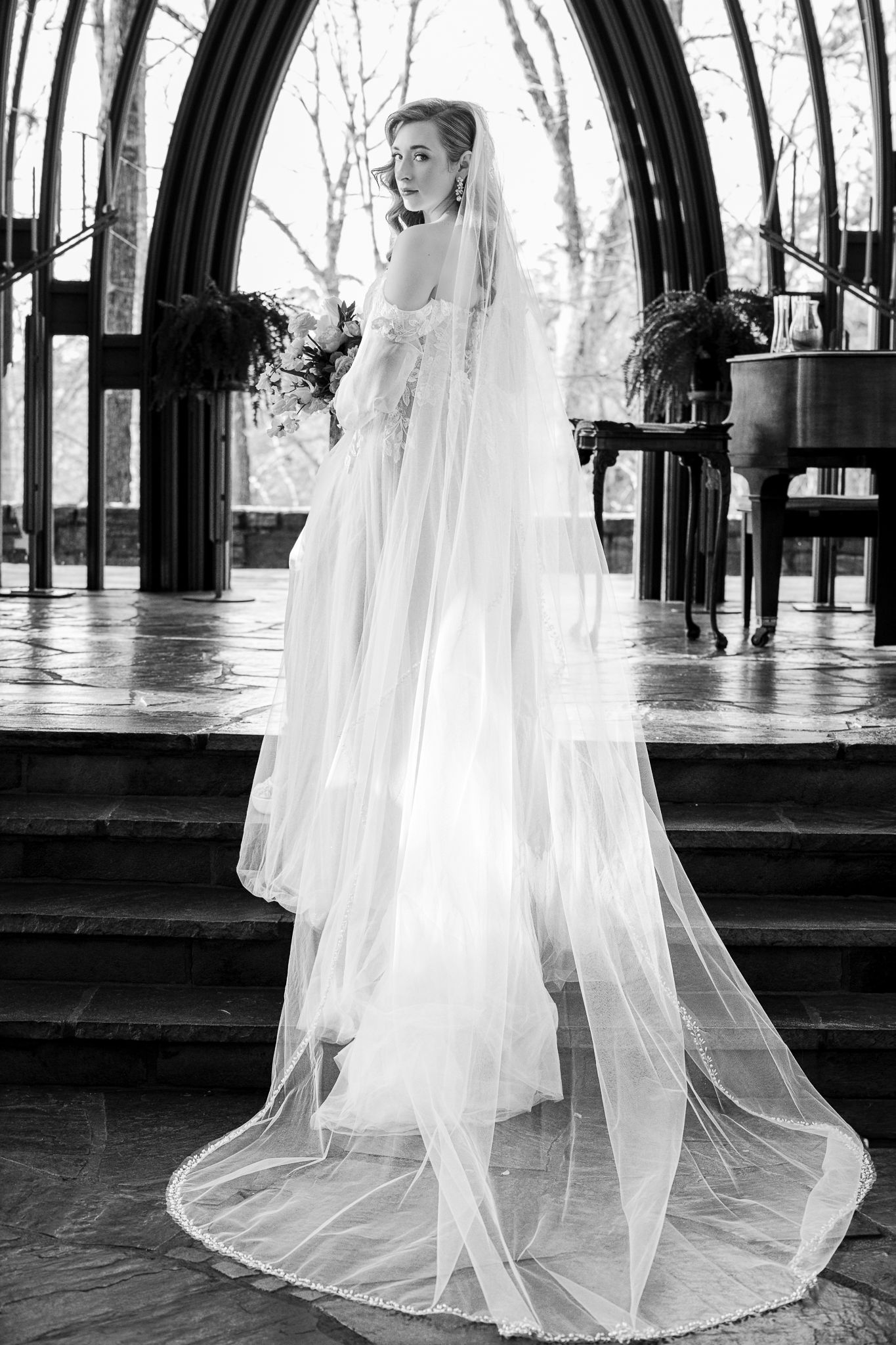 A black and white portrait of a bride smiling during a wedding ceremony in Bella Vista's Mildred B Cooper chapel