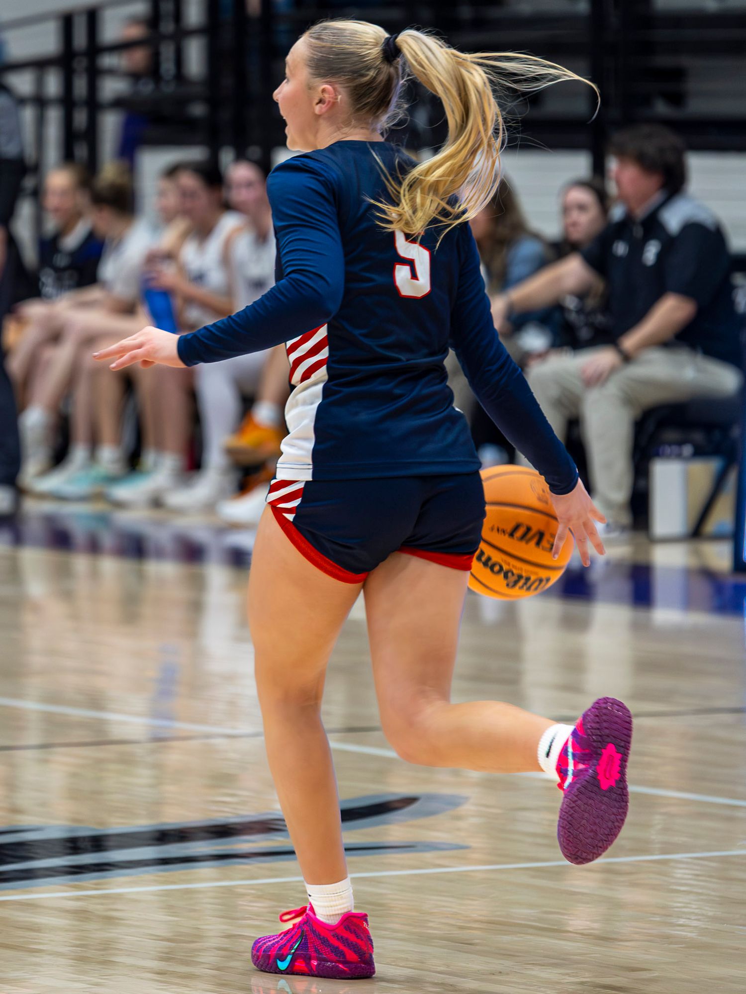 Basketball player from Providence Rogers AR dribbles the ball down court. Photo taken by Trevel Young Photography