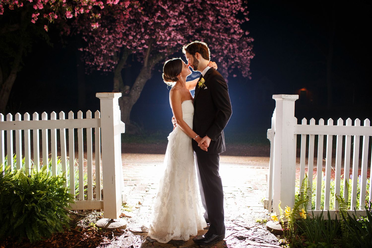 a backlit image of a bride and groom at night. This is a final ending wedding shot
