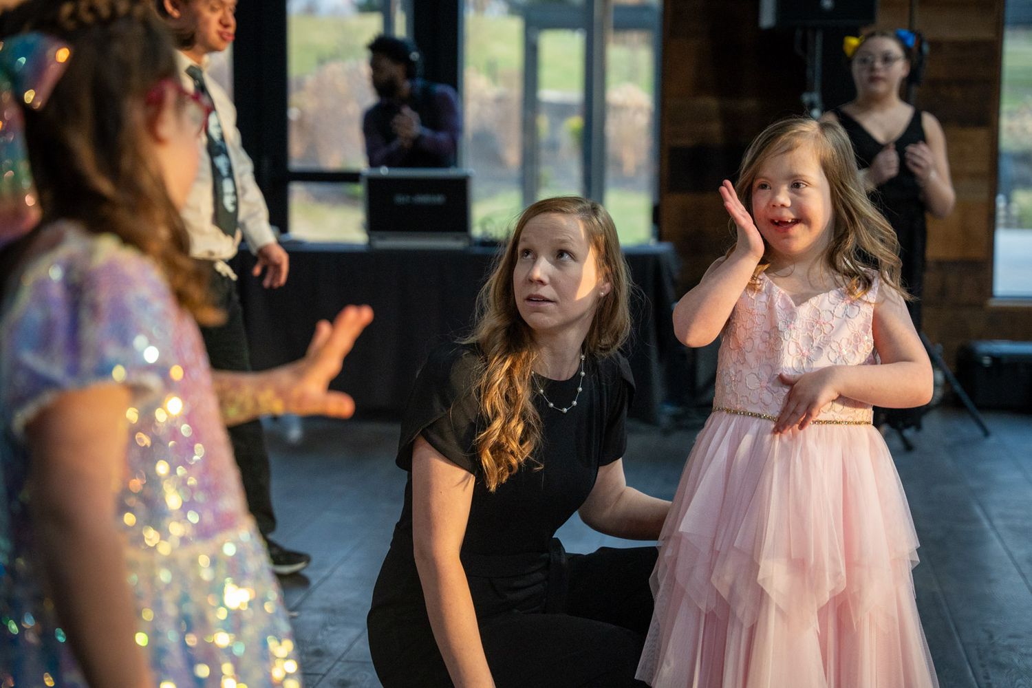 Young guests react with excitement during dance party at wedding reception.