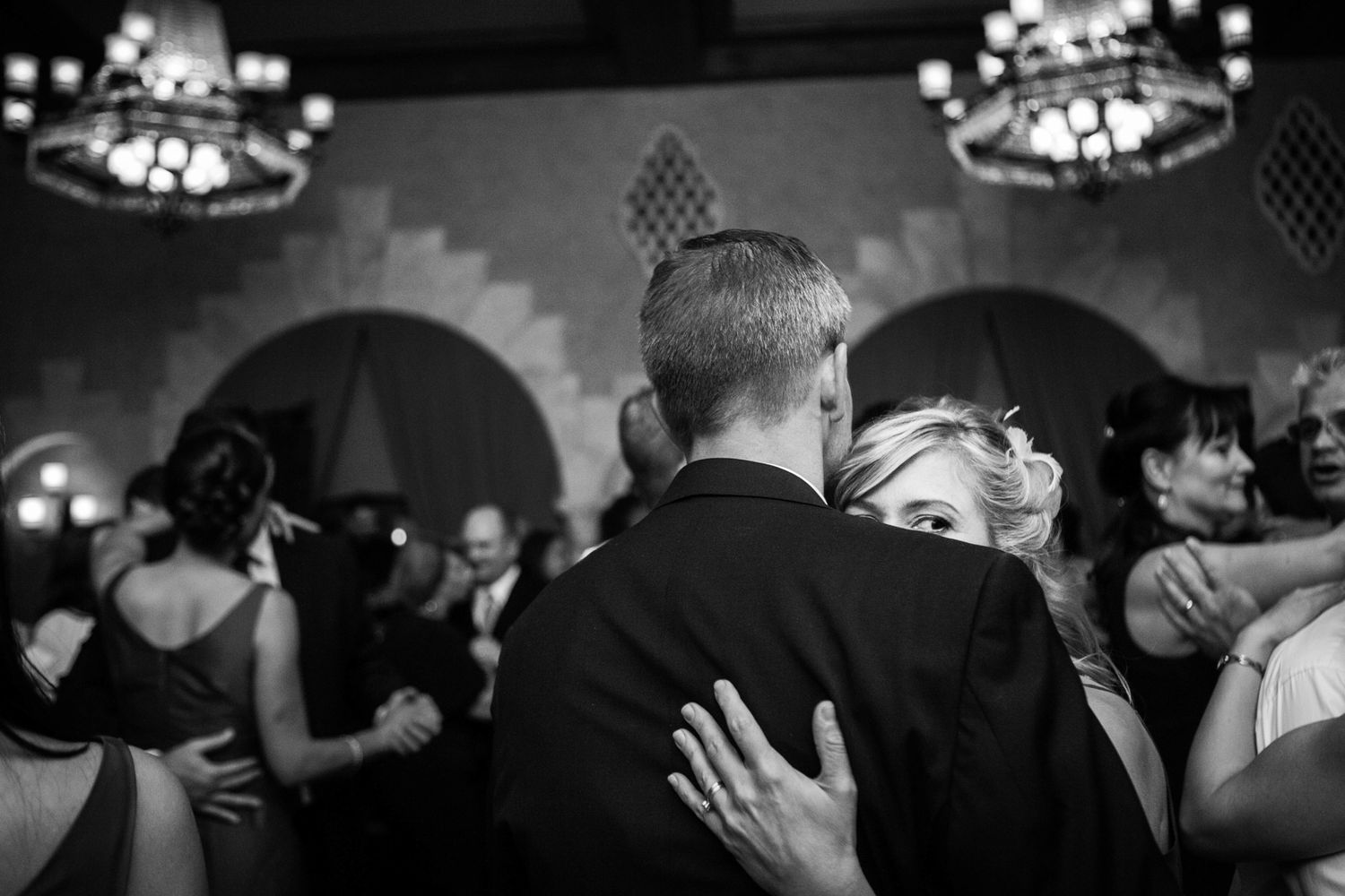 a girl peeking over a man's shoulder, a wedding reception dance photo
