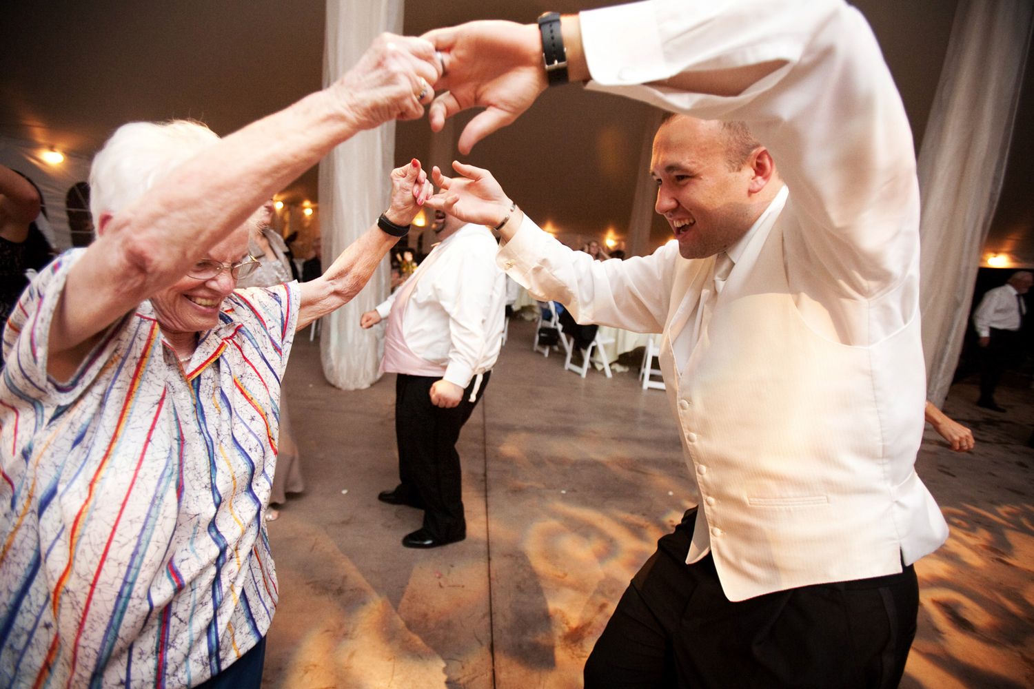 a groom dances with his grandmother at a wedding reception, fun moment