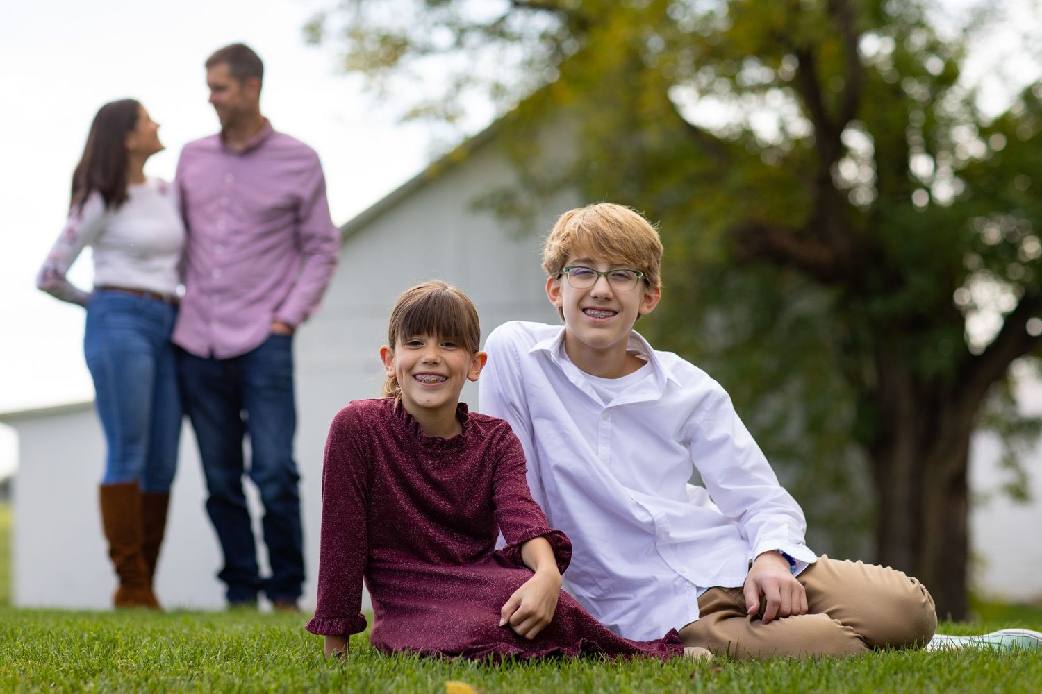 A collage of outdoor family photos shows candid moments of people sitting and interacting in a grassy park setting.