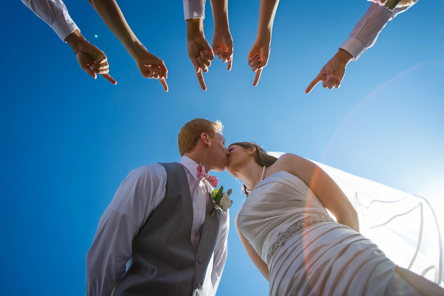 people pointing at the bride and groom when they kiss