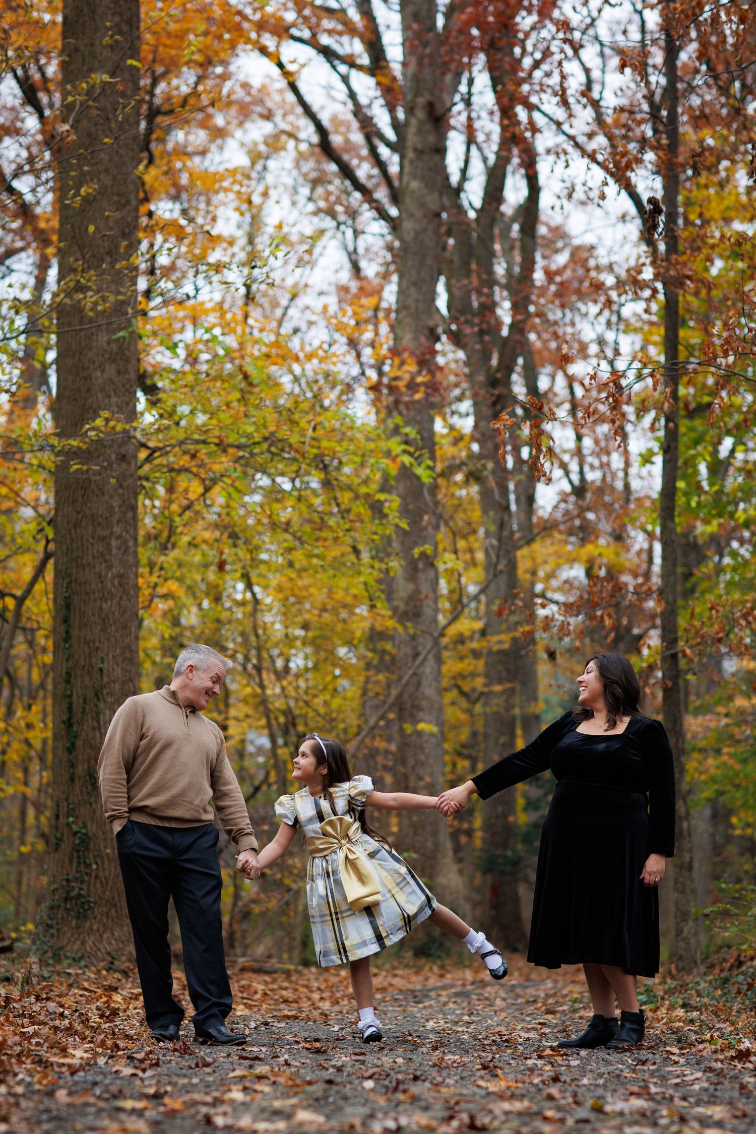 A sequence of autumn forest photos showing a couple dancing and spinning through fallen leaves and trees.