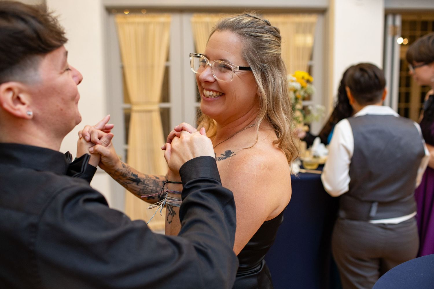 Wedding reception guests dancing and celebrating together in an elegant ballroom venue.