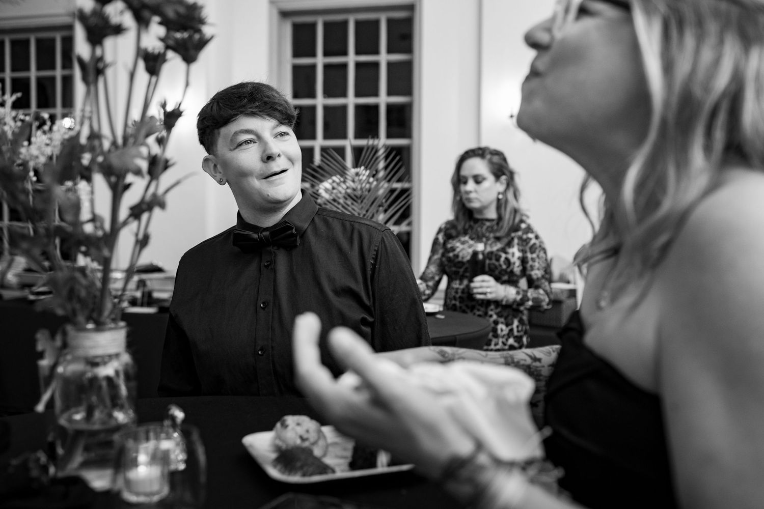 Group of attendees engaged in animated conversation at a formal social function.