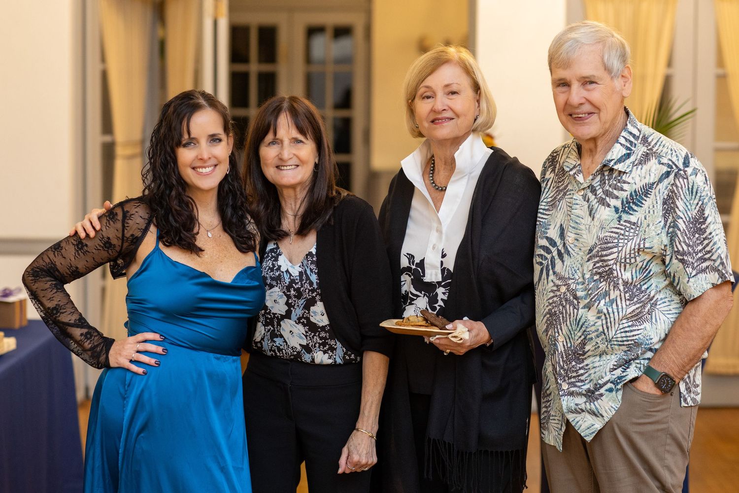 Guests mingling and sharing food at an upscale reception event.