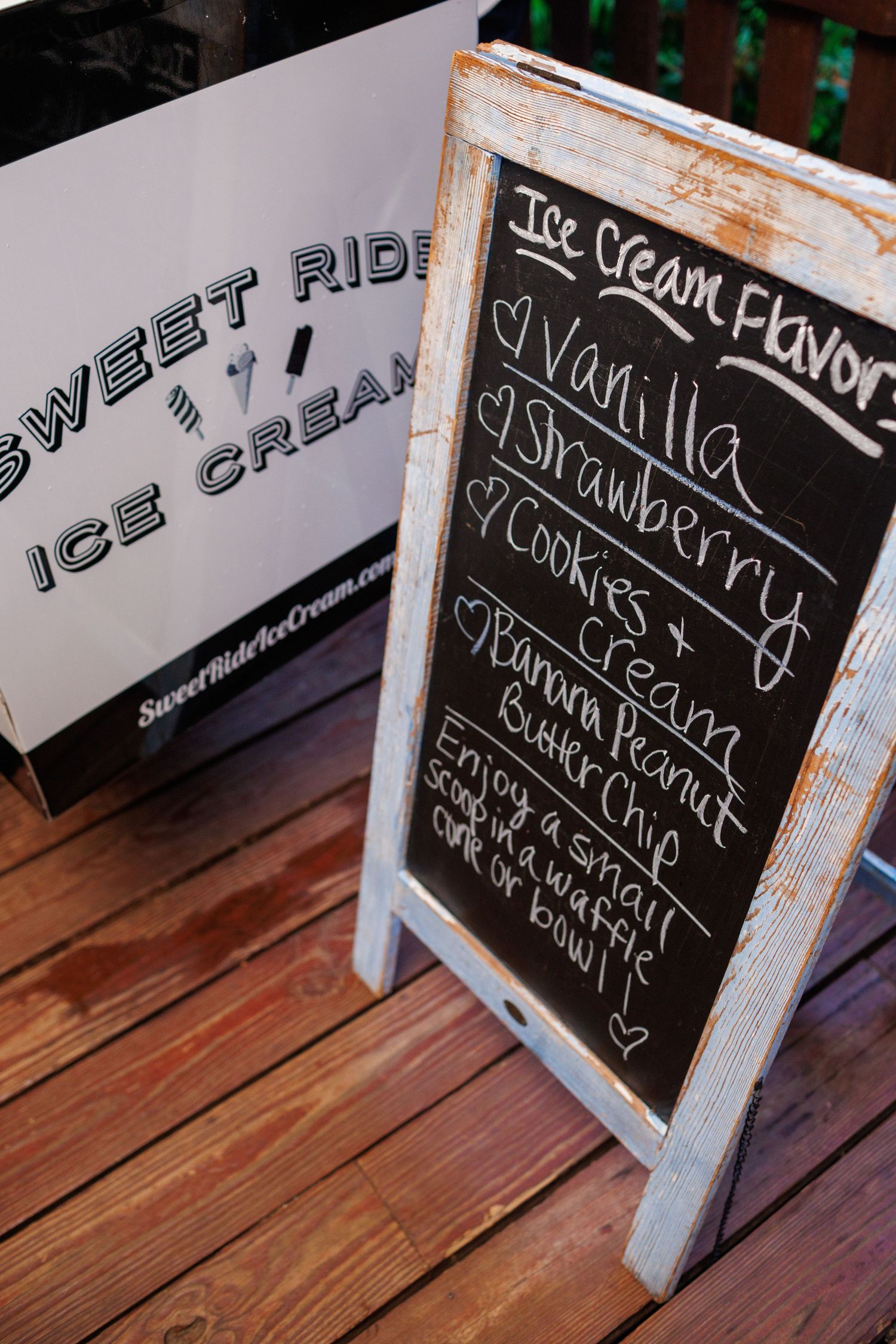 Sweet Ride Ice Cream chalkboard menu sign listing flavors including vanilla, strawberry, cookies and cream, and banana peanut butter chip.