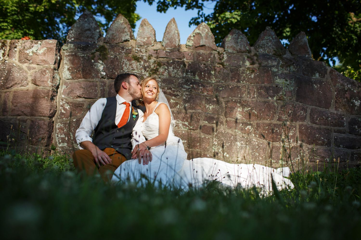 couple sitting by a stone fence