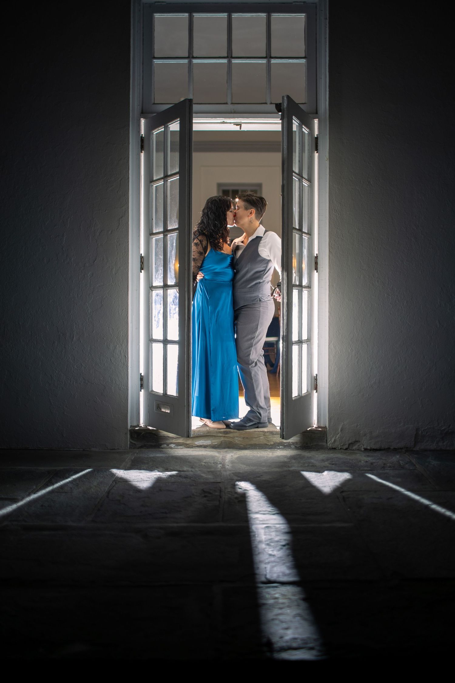 Dramatic silhouette photo through doorway with bright light streaming in against dark interior.
