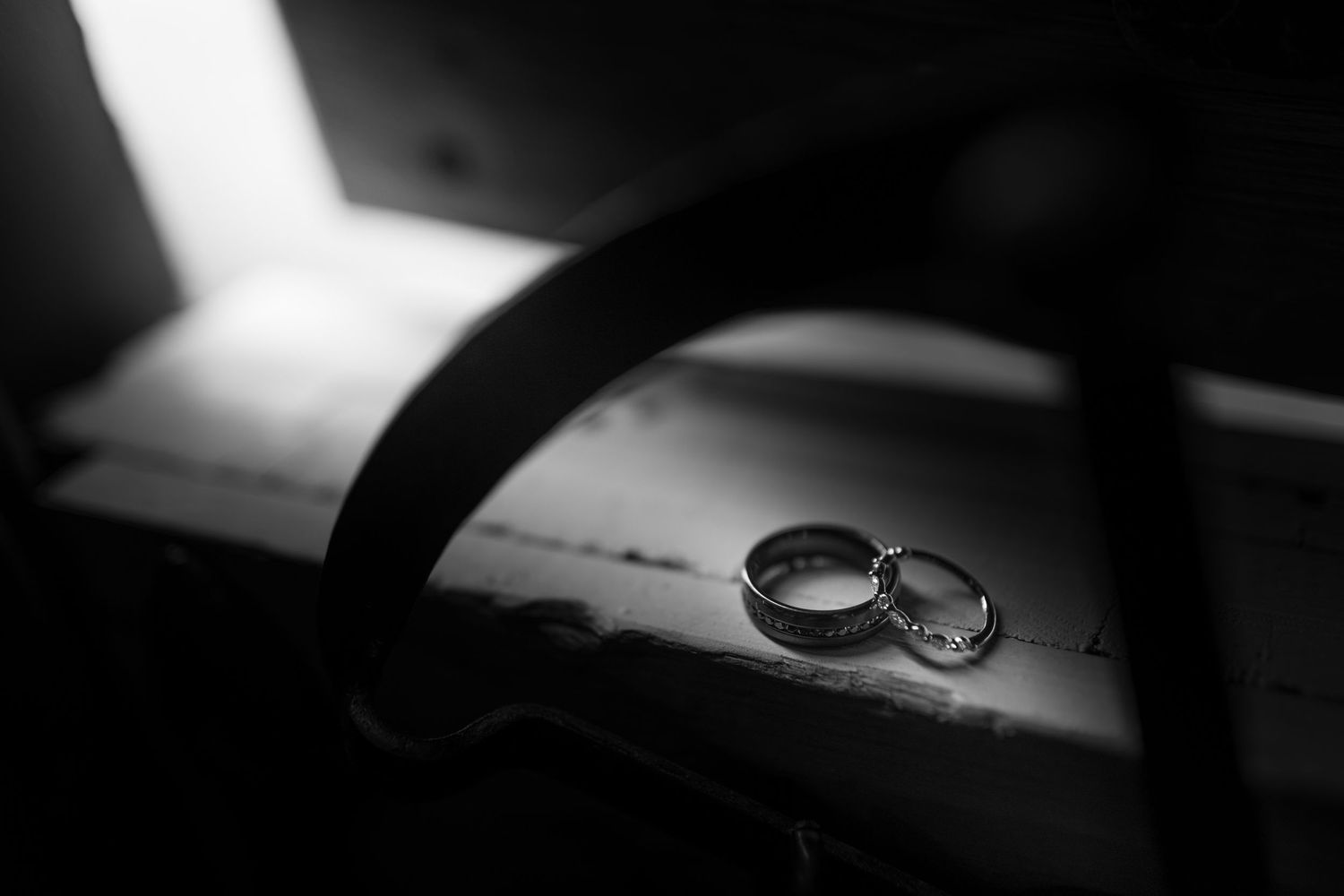 Black and white artistic wedding ring photo series showing close-up details and shadows.