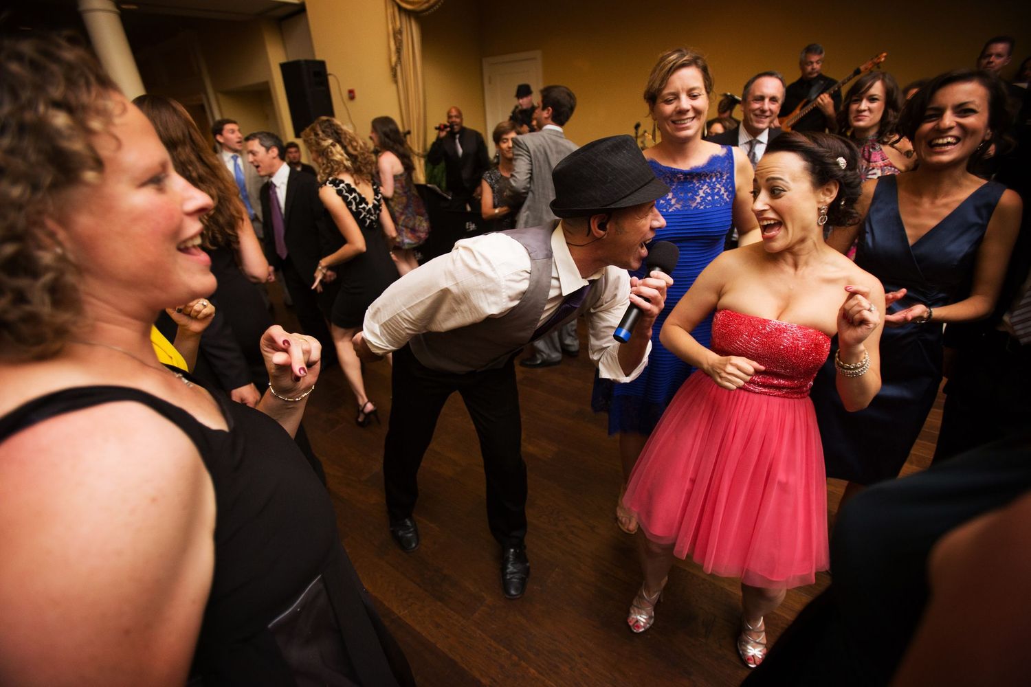 Energetic party guests dancing and laughing together on a dance floor at a celebration event.