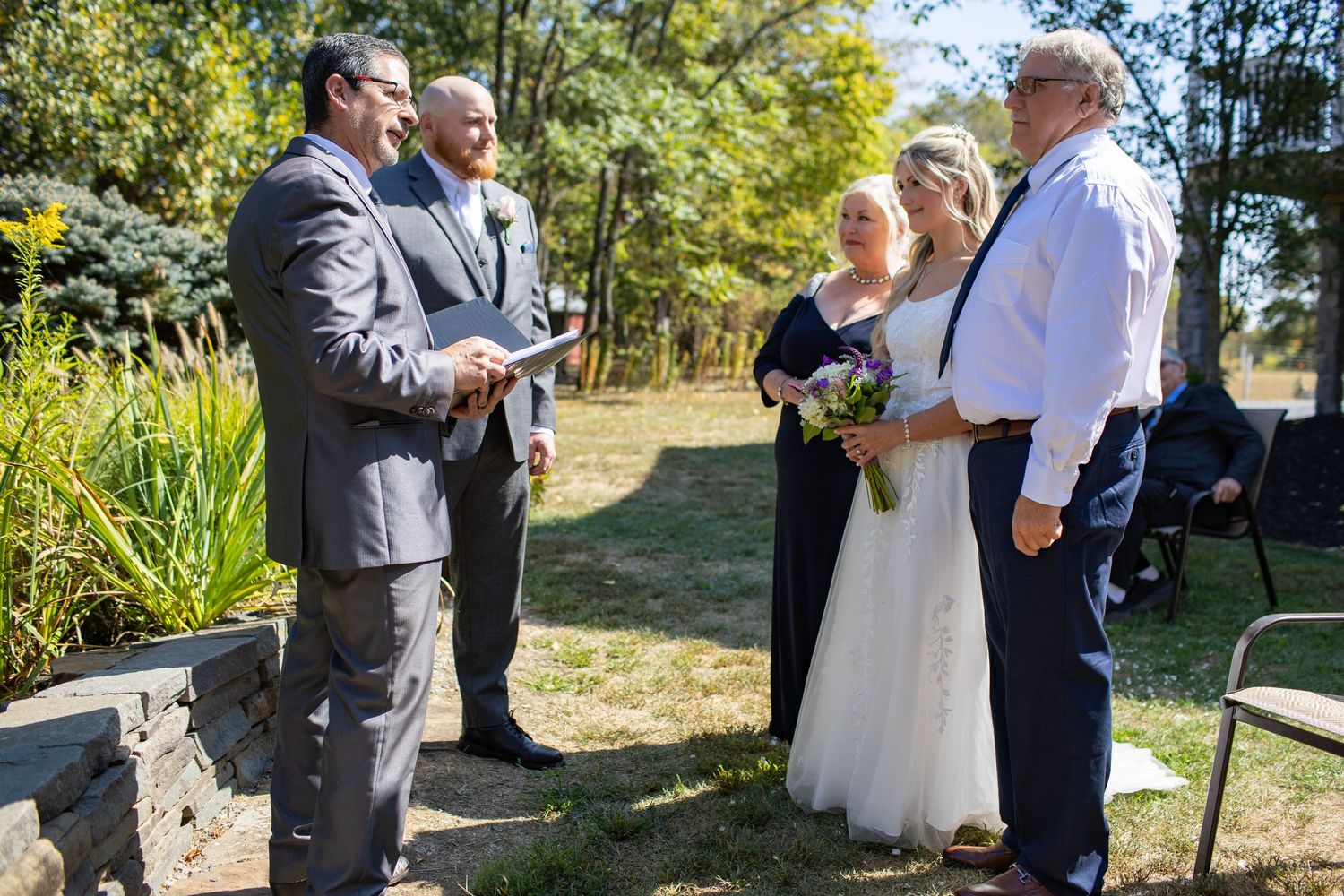 Five connected images of an outdoor wedding ceremony showing bride and groom exchanging vows on a sunny autumn day.