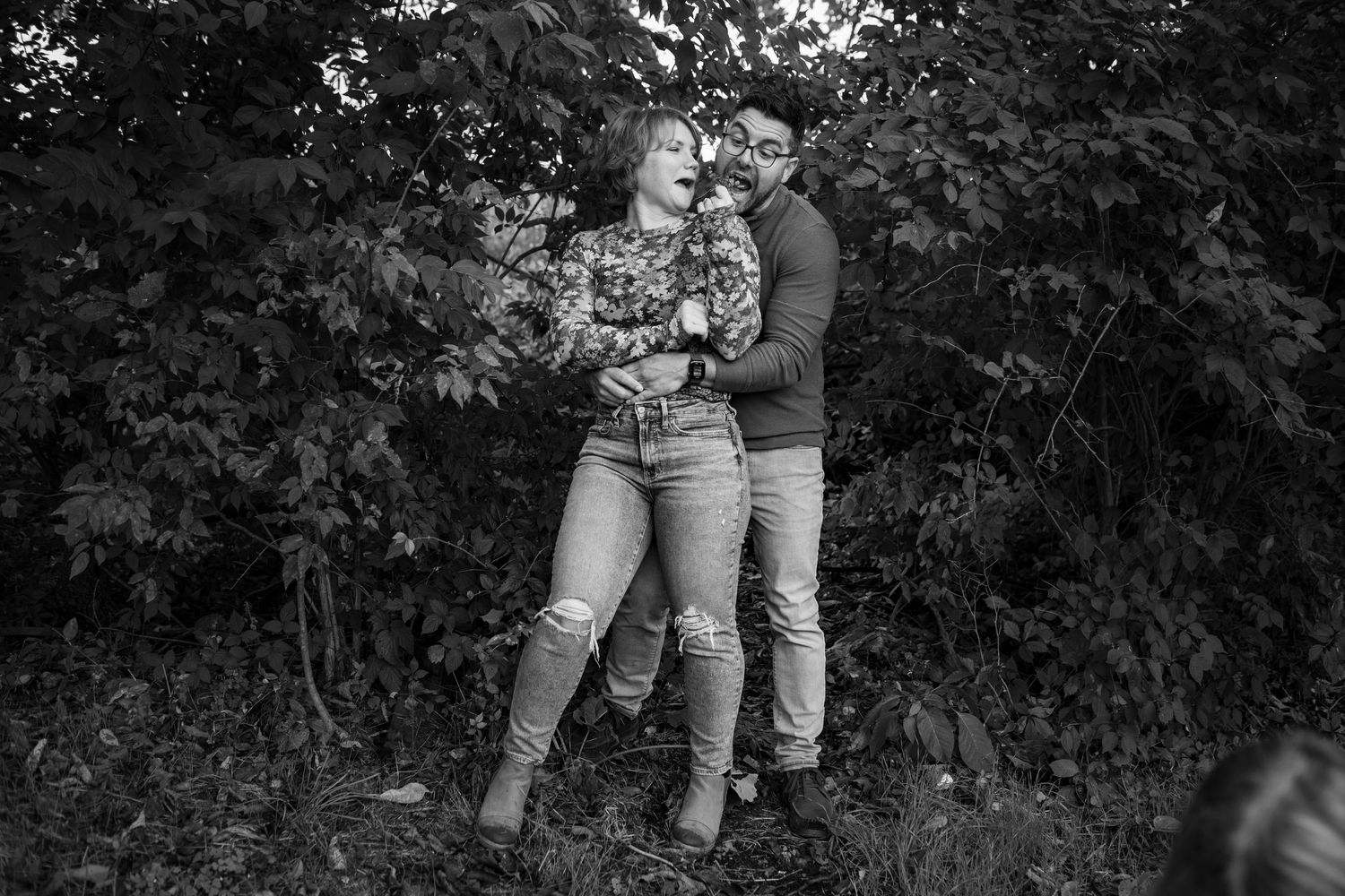 Black and white sequence of a couple sitting together outdoors among trees.