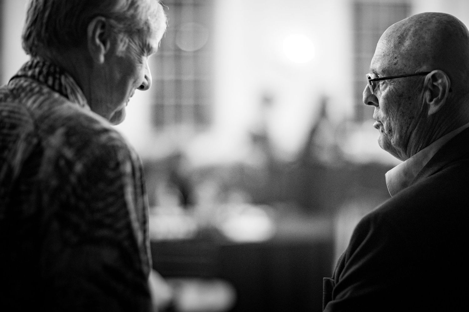Black and white candid shots of people in conversation at a social gathering.