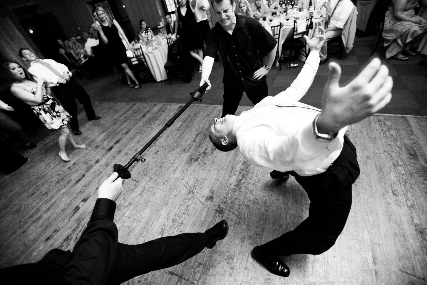 People dance energetically on a wooden floor at a social dance event from various dynamic angles and positions.
