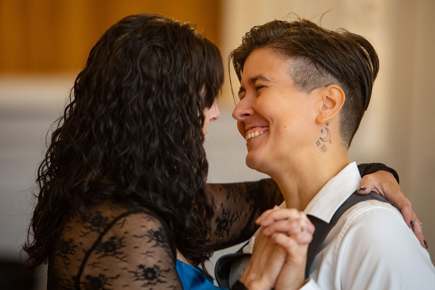Candid moment captured of people sharing joyful laughter during an indoor event.
