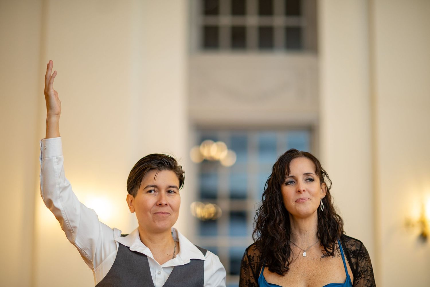 Guests celebrating with raised arms during a lively indoor celebration.