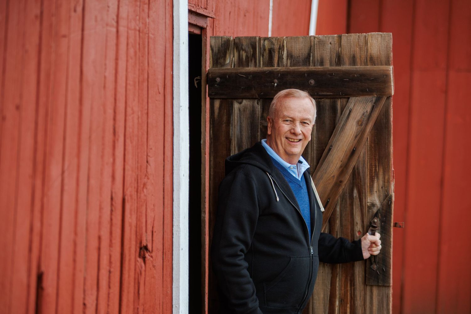 A series of four candid outdoor photos taken against a rustic red barn wall in natural lighting.