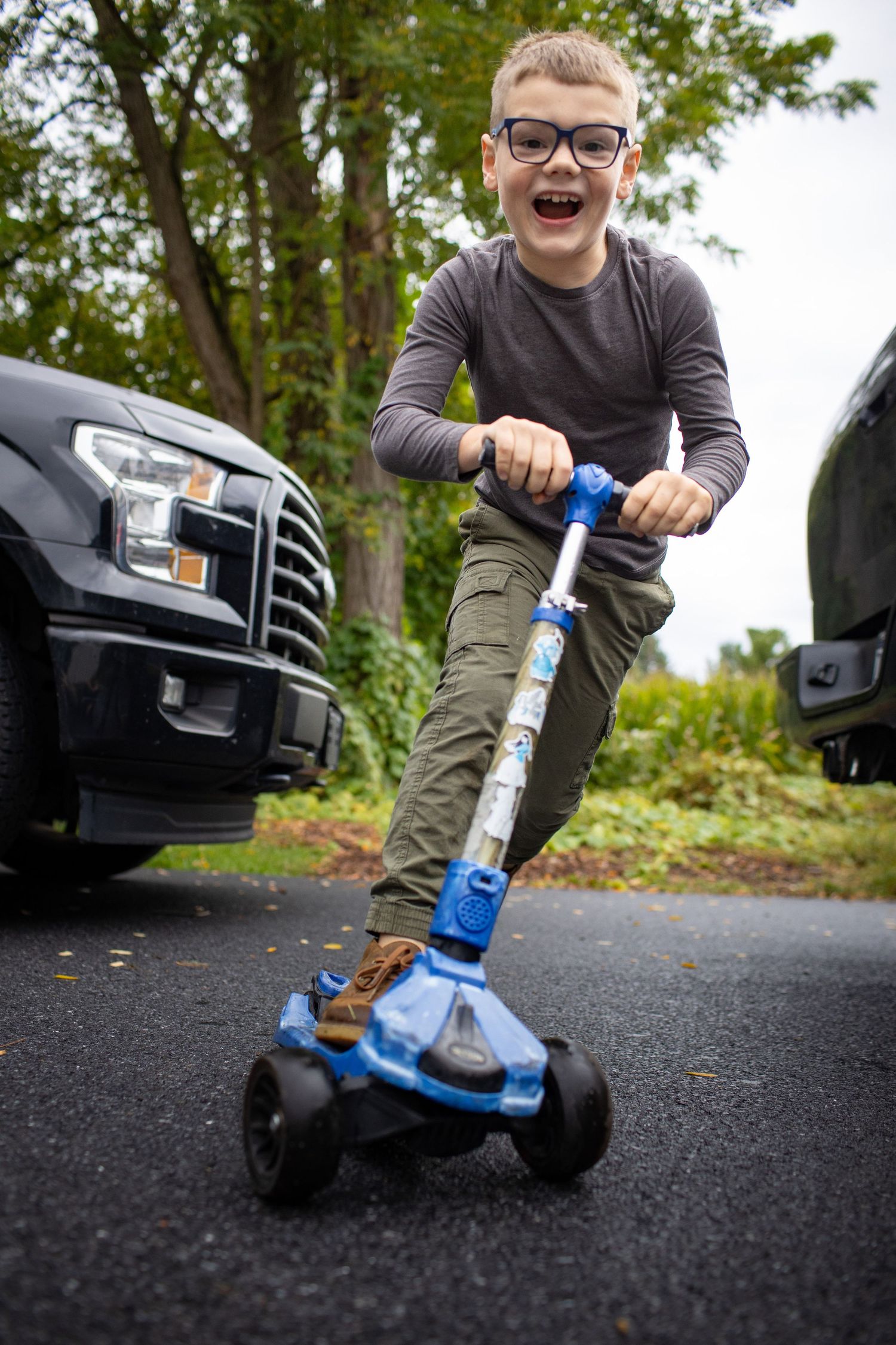 Low angle shot of someone riding a blue flicker scooter on asphalt pavement.