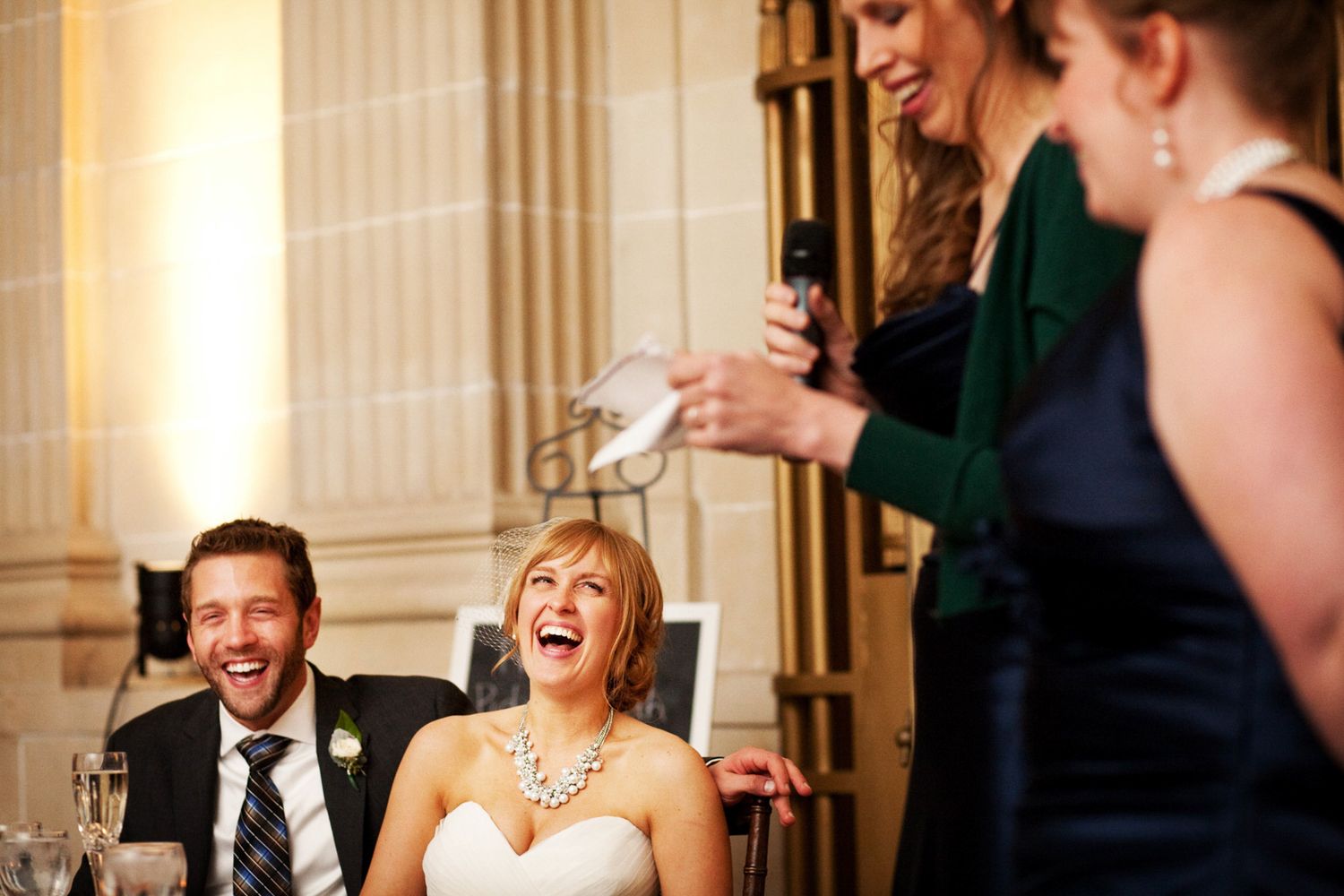 laughing couple at a party during a speech, wedding