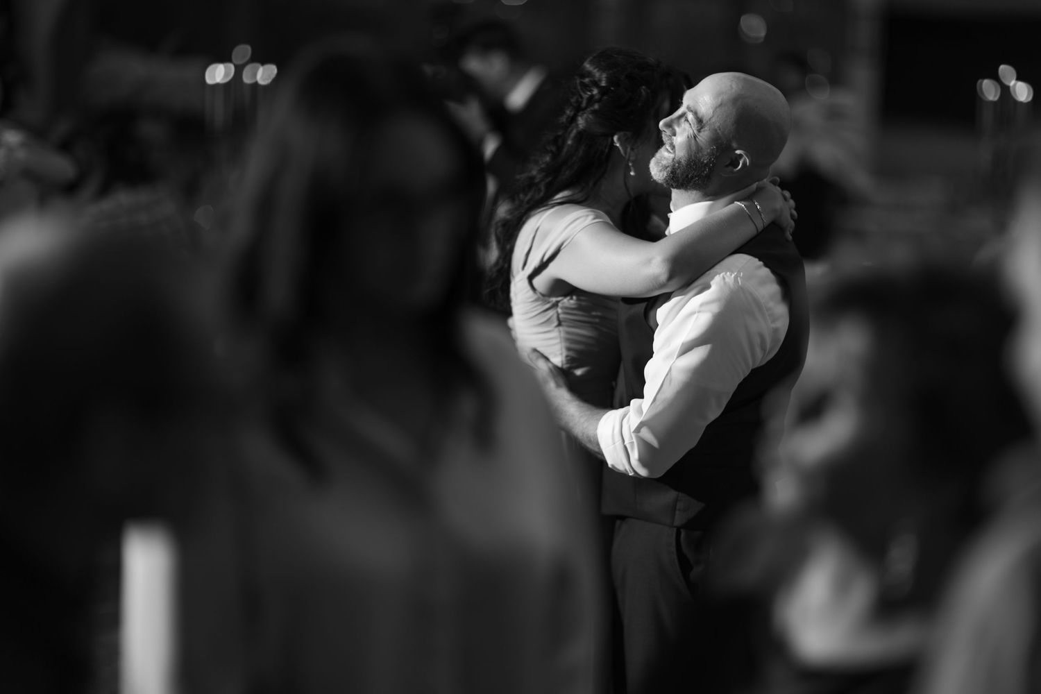 Black and white candid shot of wedding guests during an evening celebration.