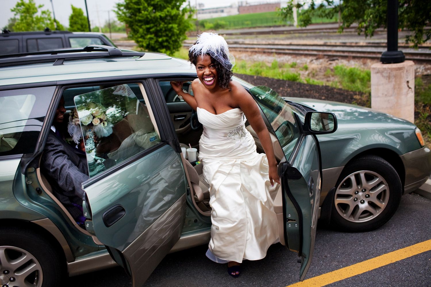 bride getting out of a Subaru outback laughing