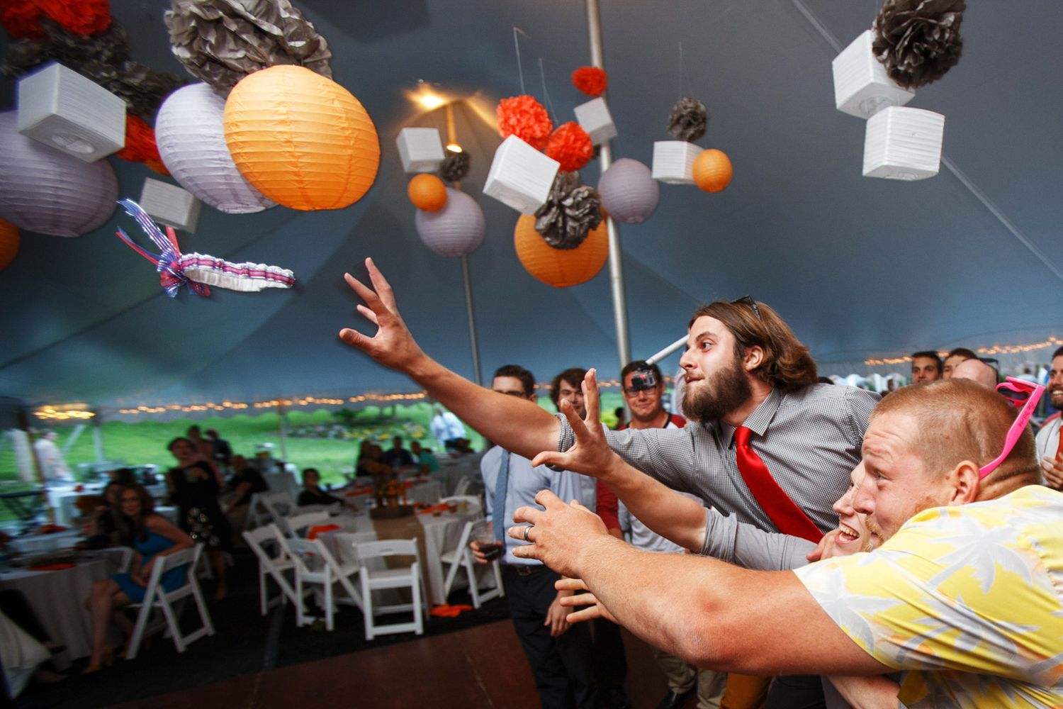 guy grabbing for the garter at a wedding reception