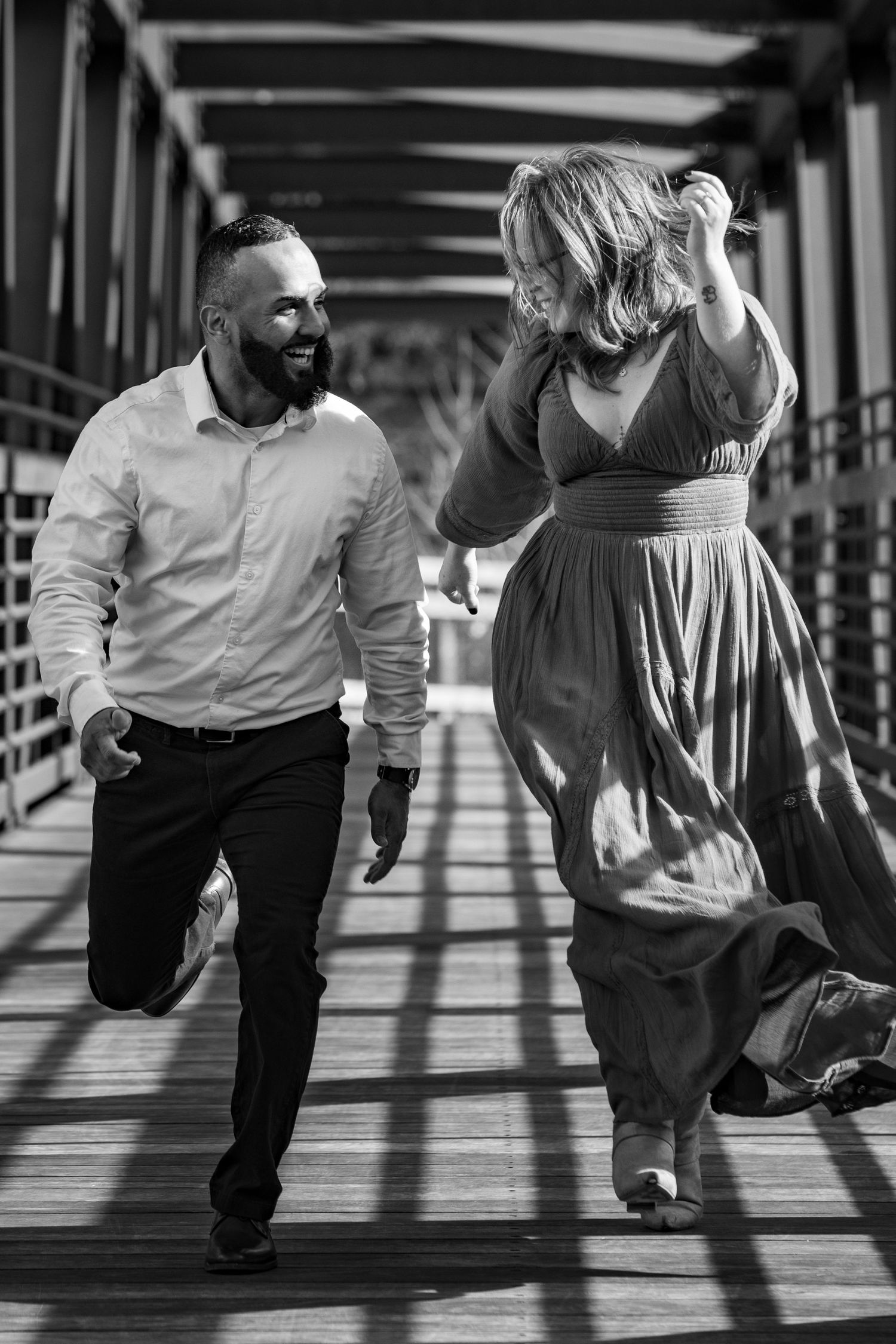 Black and white sequence of a couple dancing dynamic floor movements in a sunlit studio bridge.