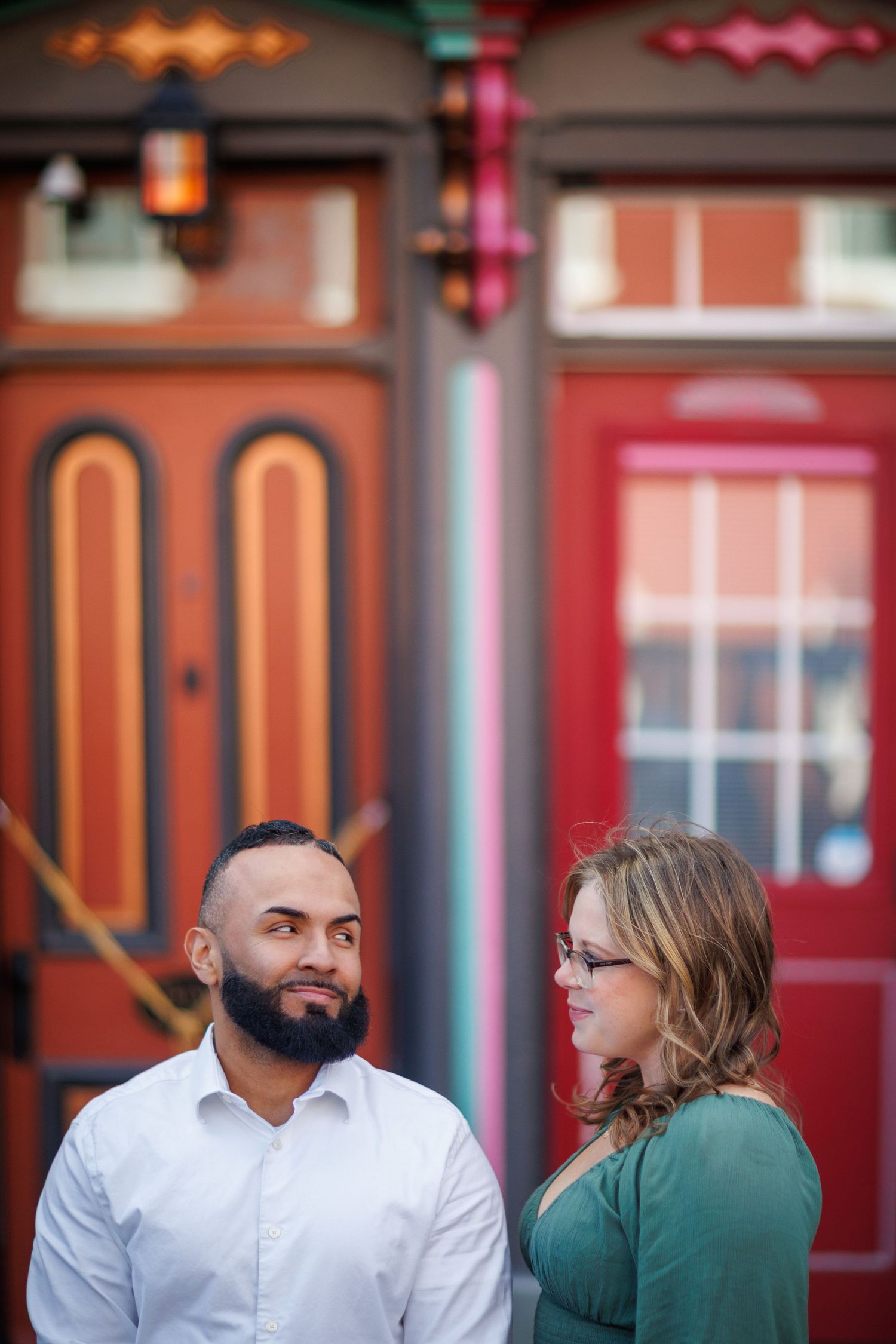 A romantic sequence under decorative lighting at a restaurant exterior with red accents.