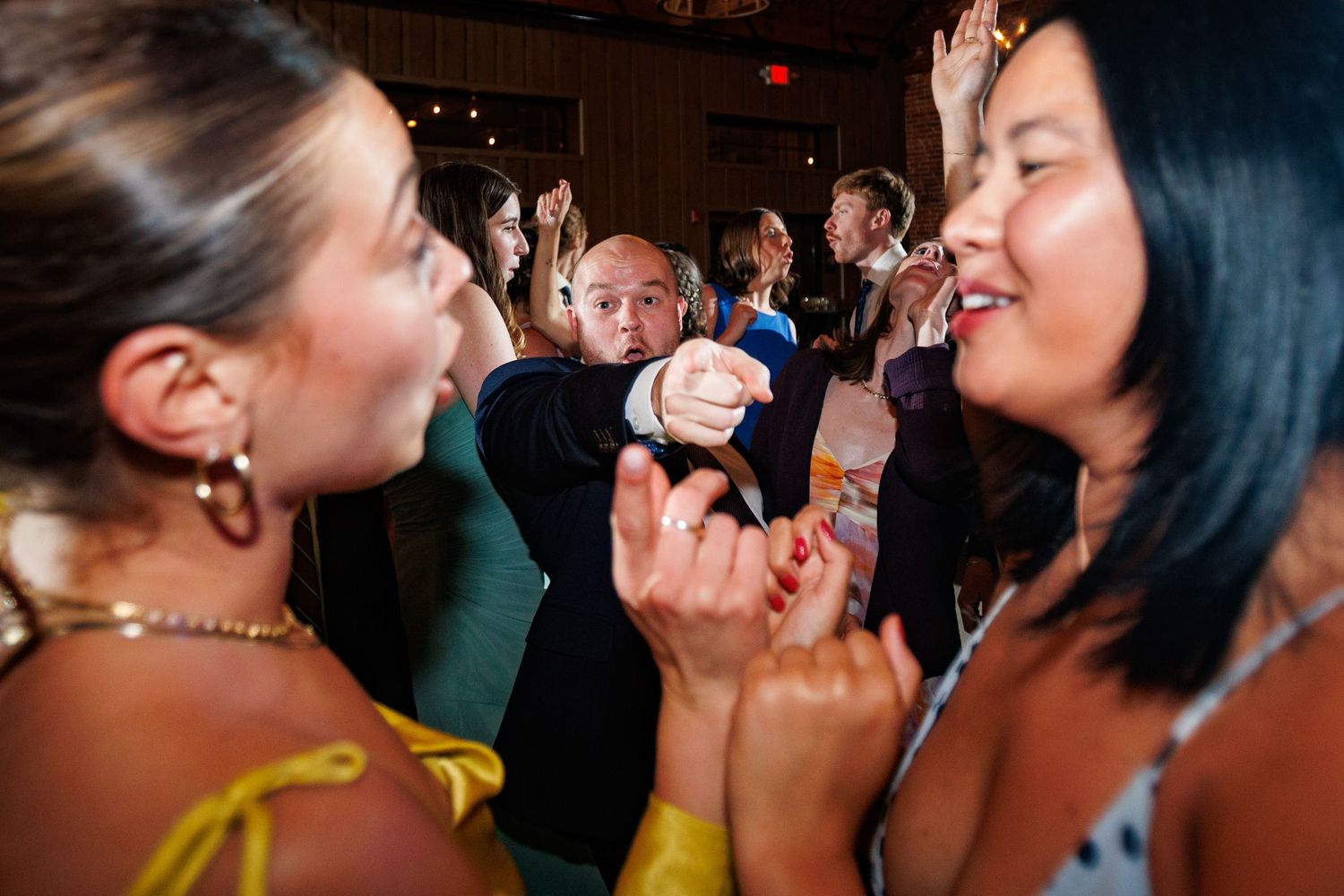 People dancing and celebrating at a lively indoor party event with colorful lighting.