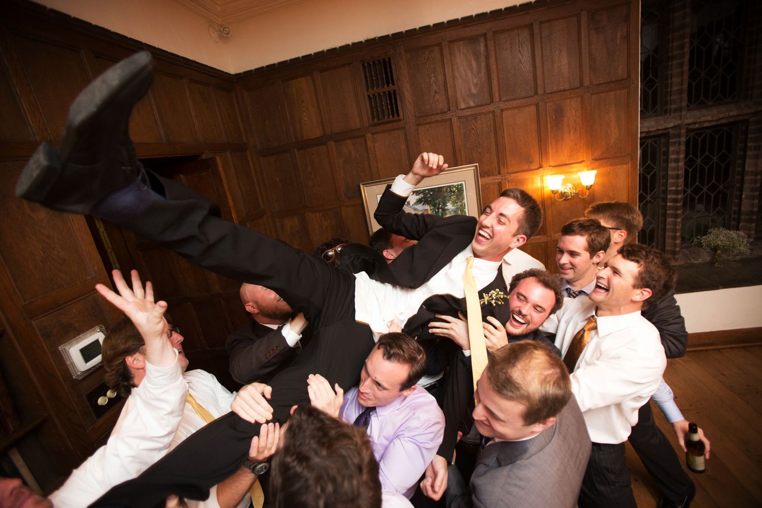 Photojournalistic, wedding reception photo of crazy guys dancing