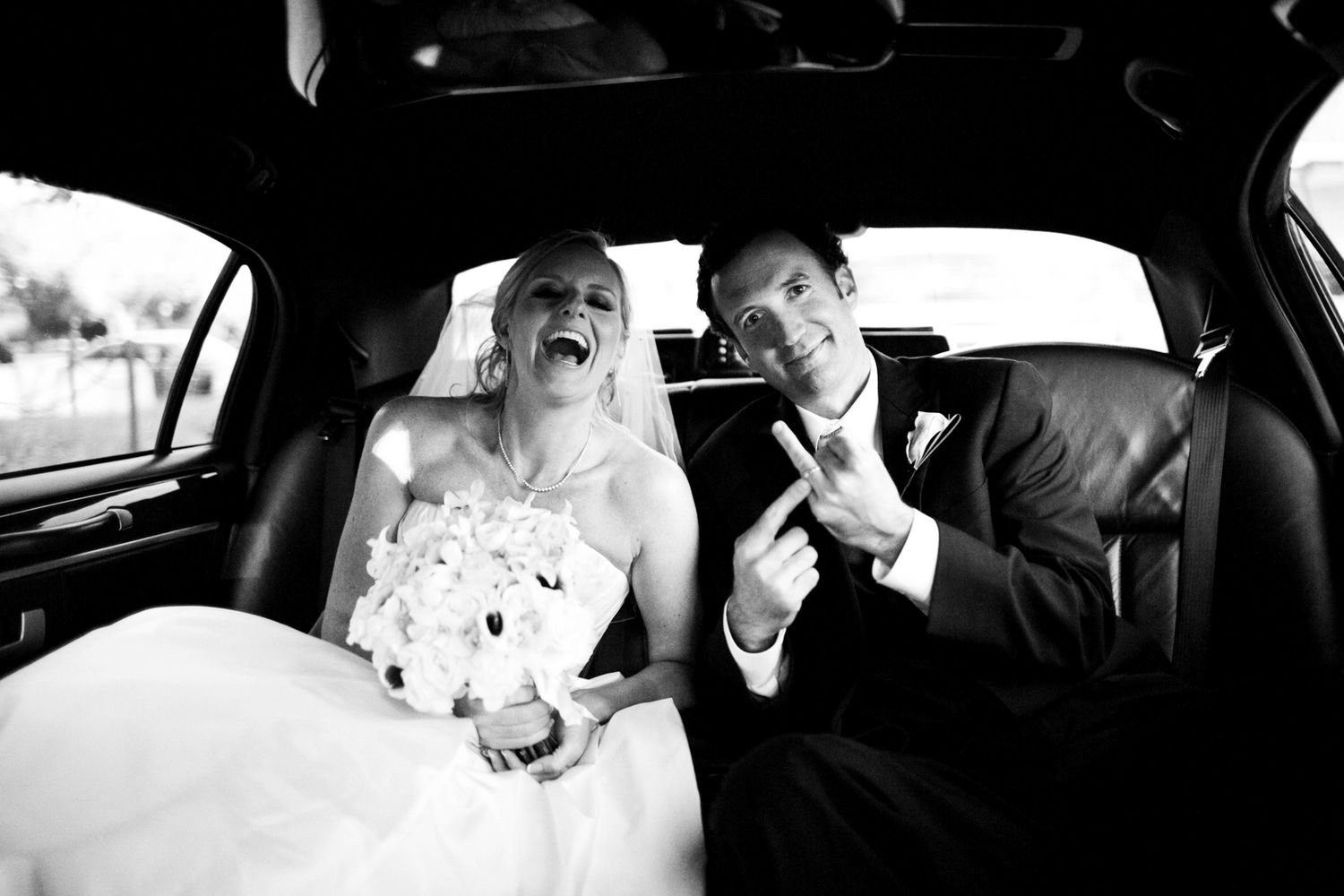 unique groom photo in a limo whipping the bird