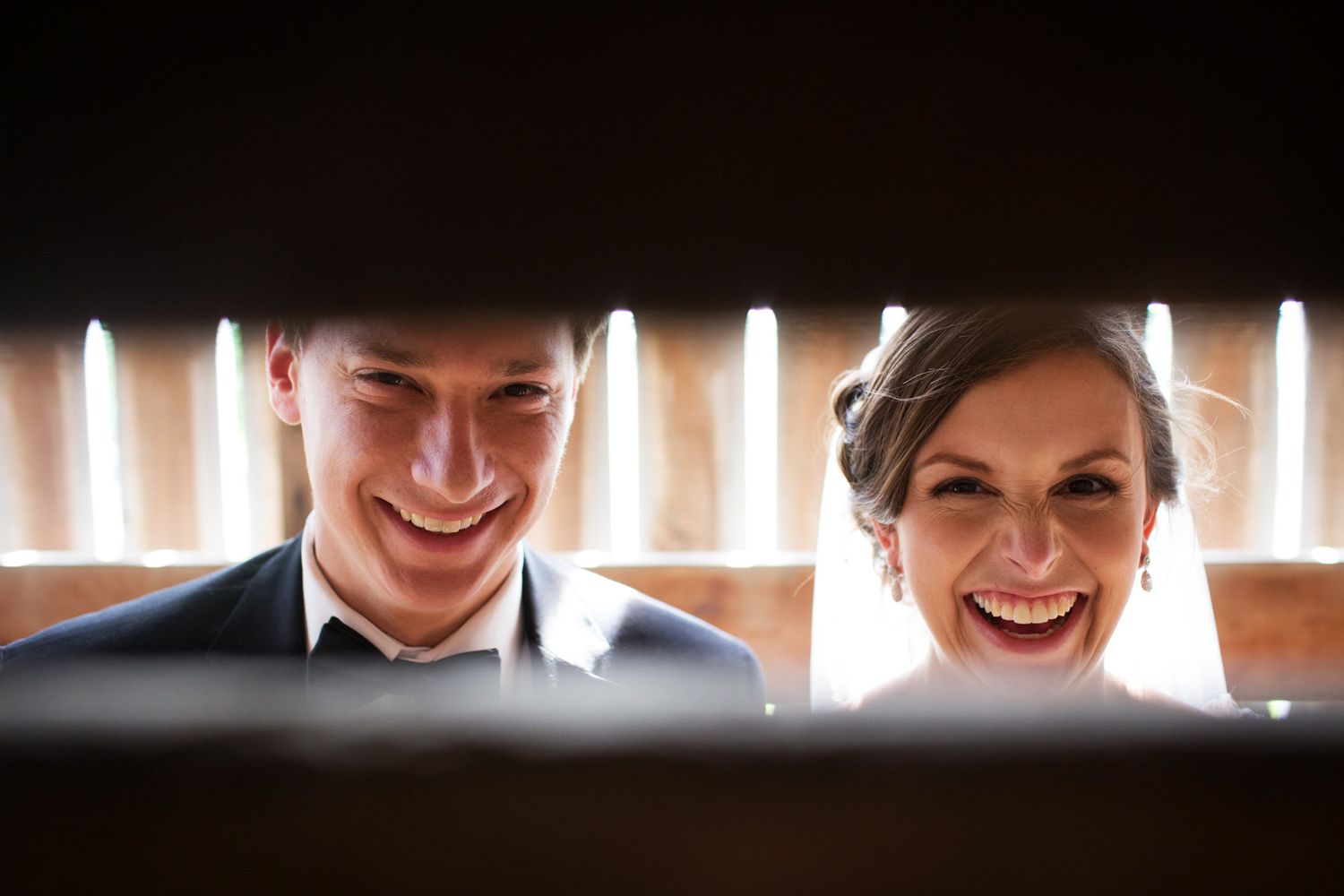 laughing bride and groom in a barn