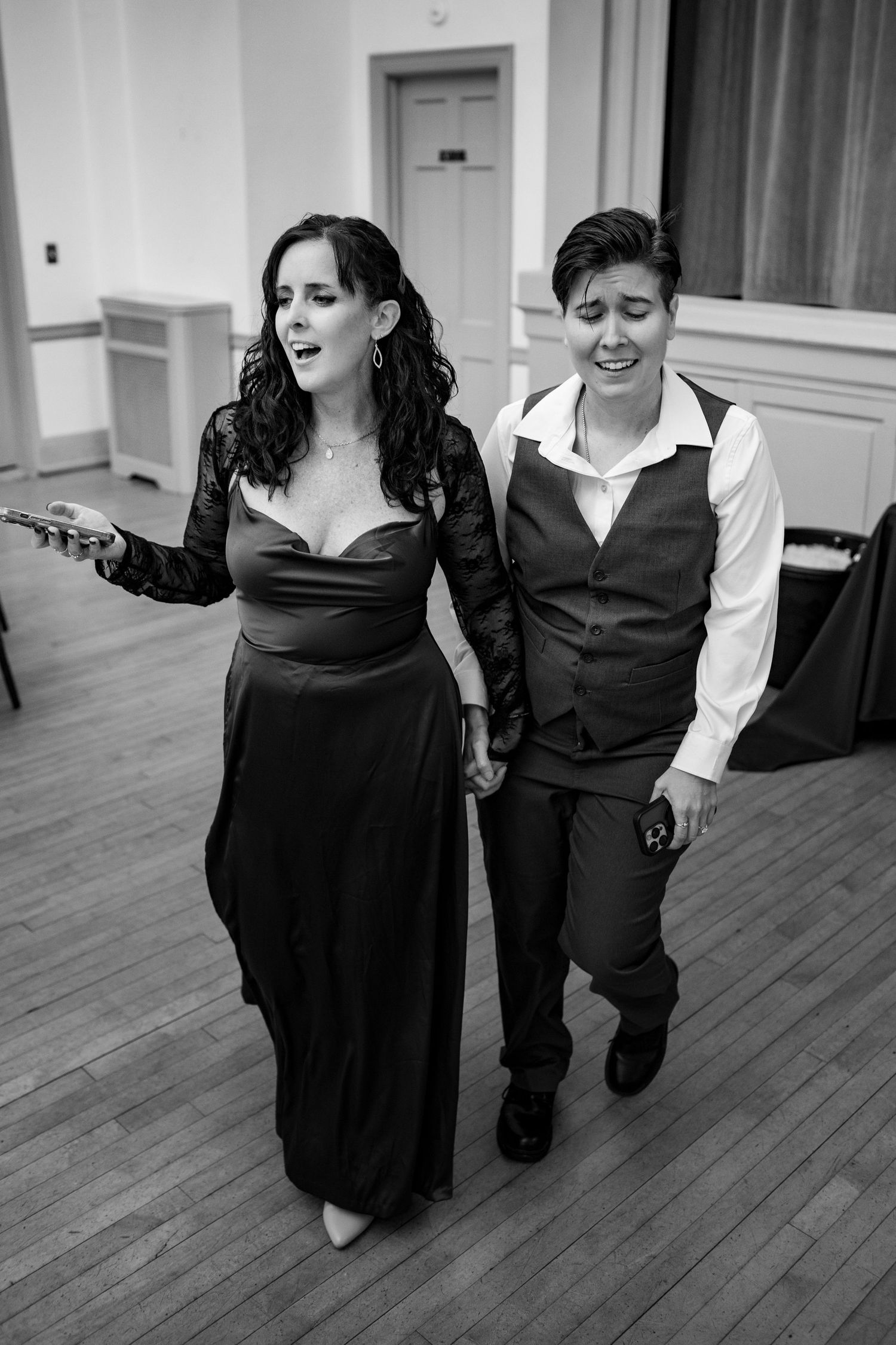 People dancing and moving across a hardwood floor during a formal event.