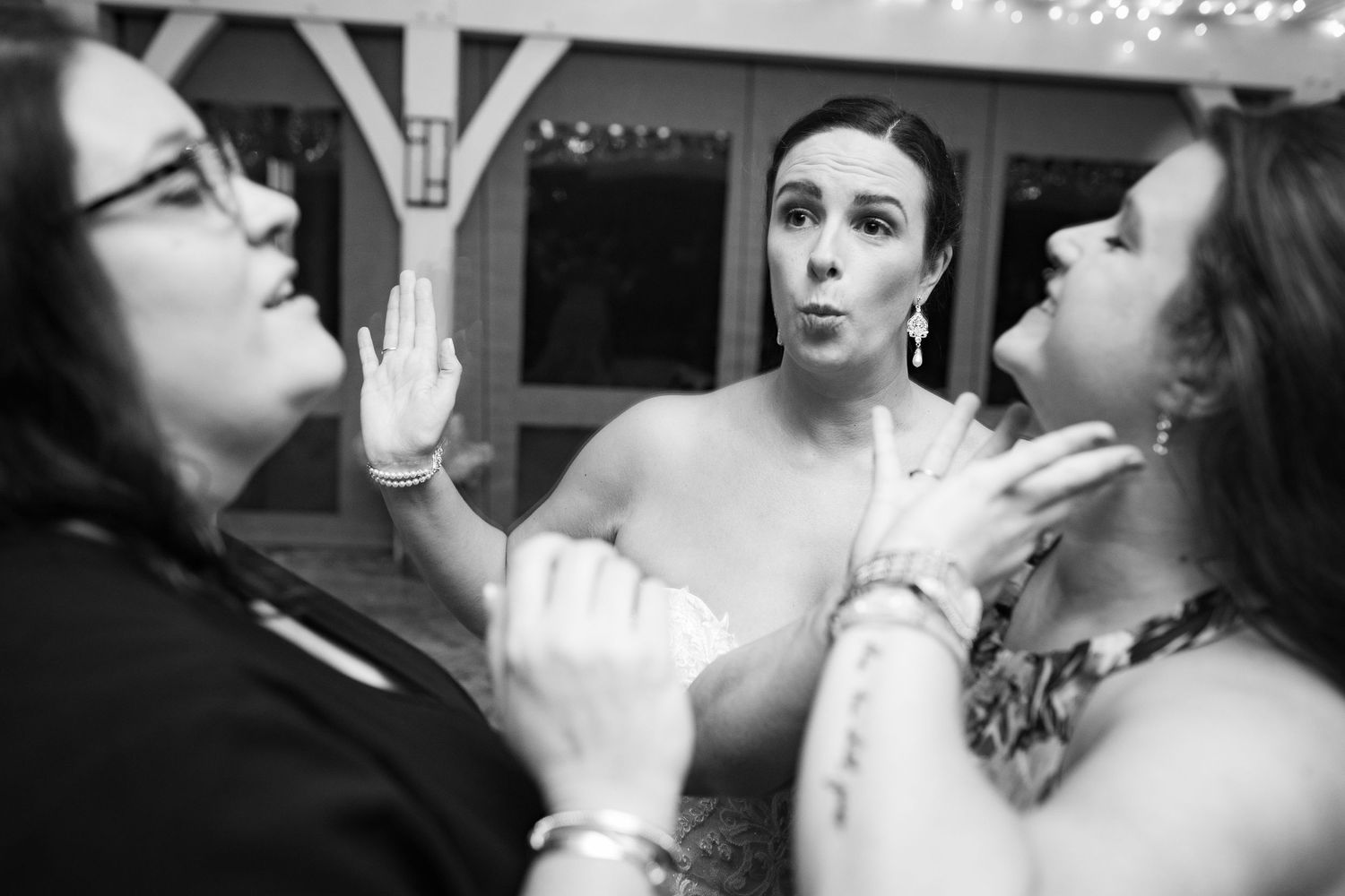Black and white photo of wedding party toasting with champagne glasses.