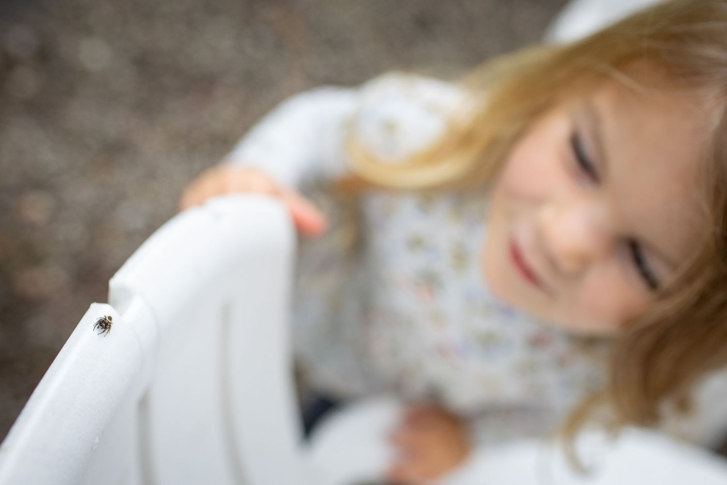 A soft focus artistic portrait shows a child in a white and floral outfit with flowing blonde hair.