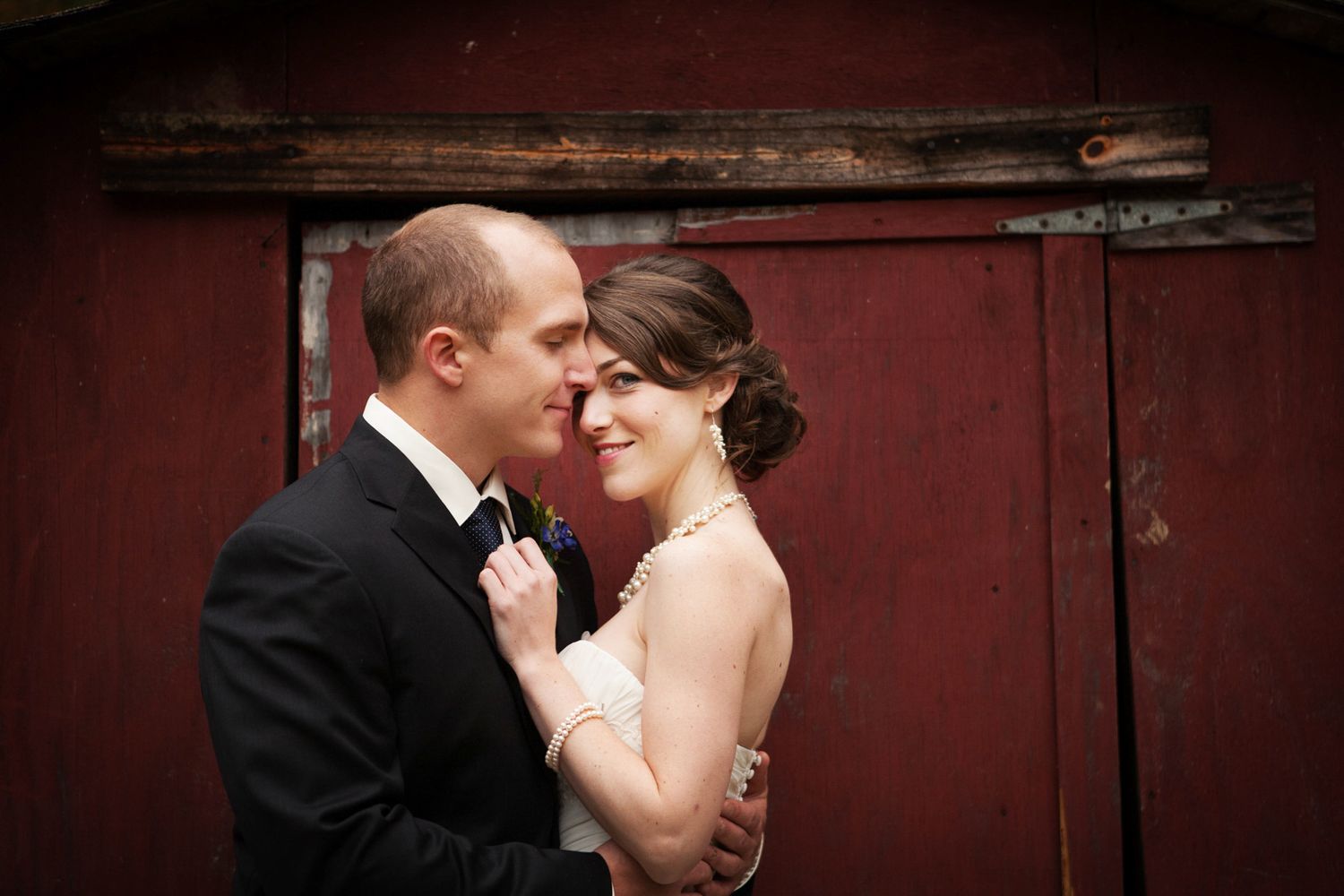 bride and groom and red barn
