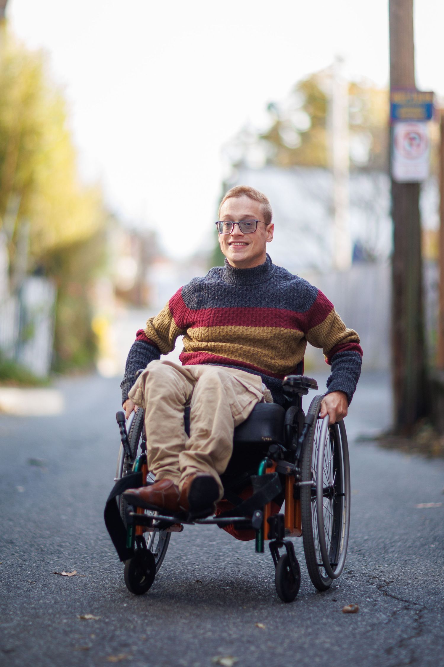 Multiple views of someone in a wheelchair wearing a colorful striped sweater on an urban street.