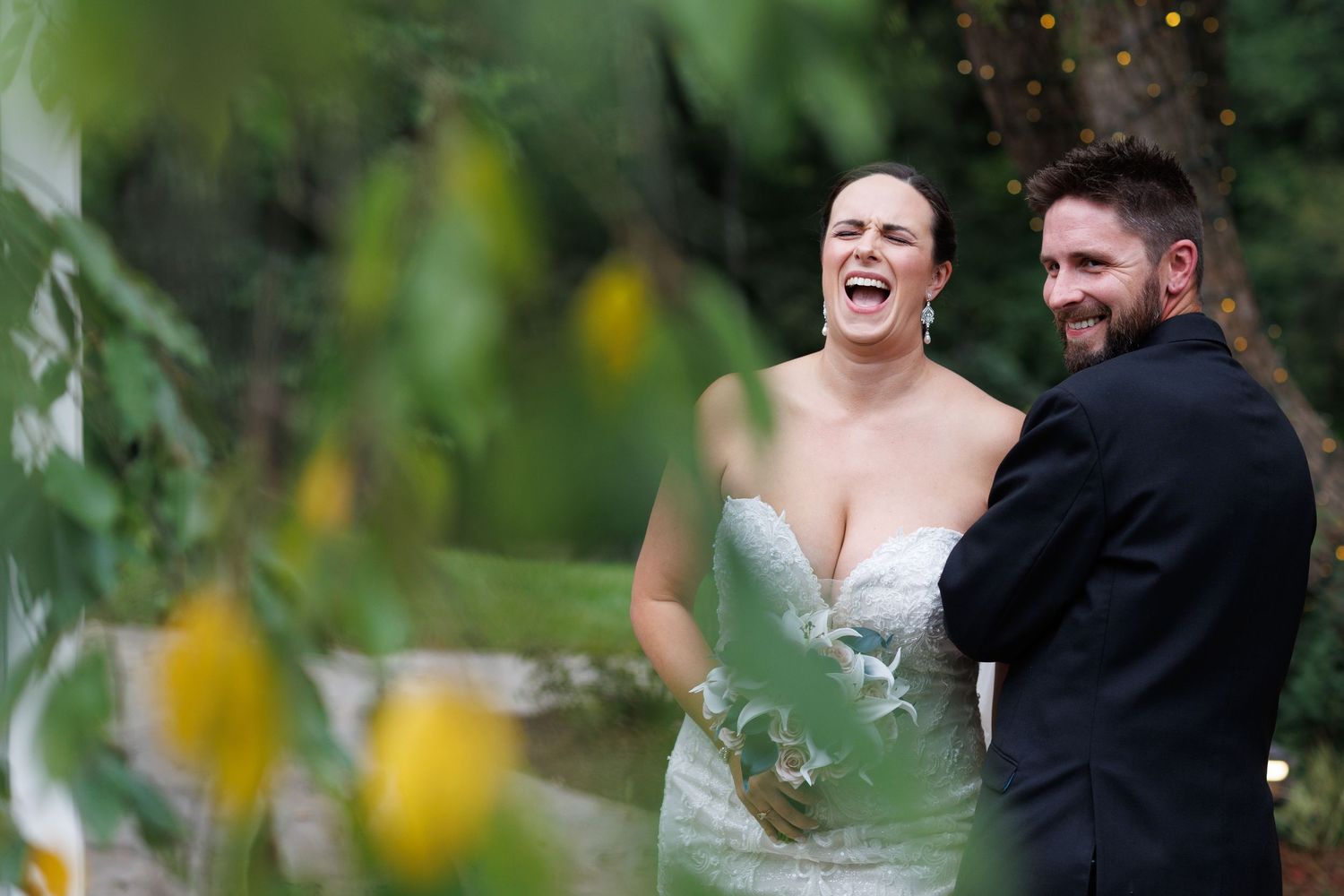 Happy couple sharing a candid moment outdoors surrounded by greenery.