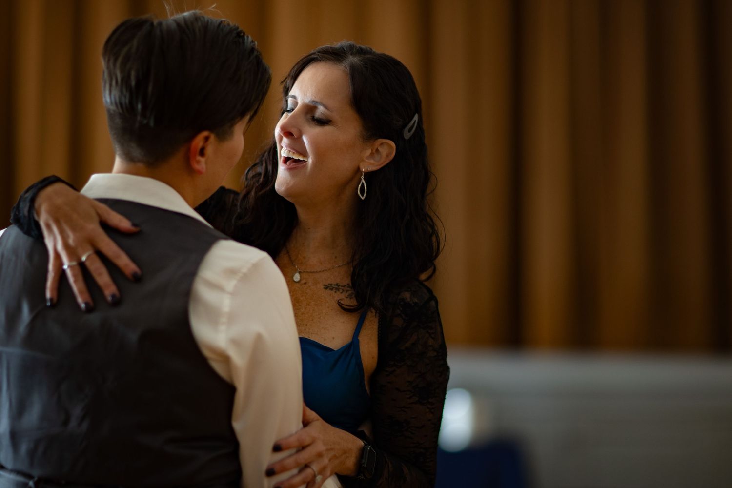 A couple shares an intimate dance moment in formal attire at an evening event.