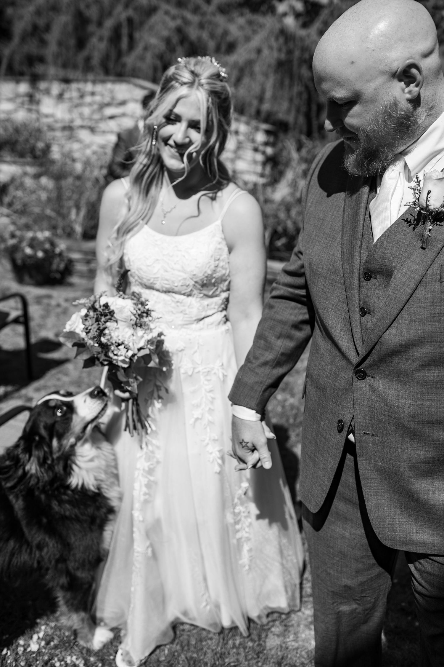 Black and white wedding photo series showing newlyweds laughing and embracing in candid outdoor moments.