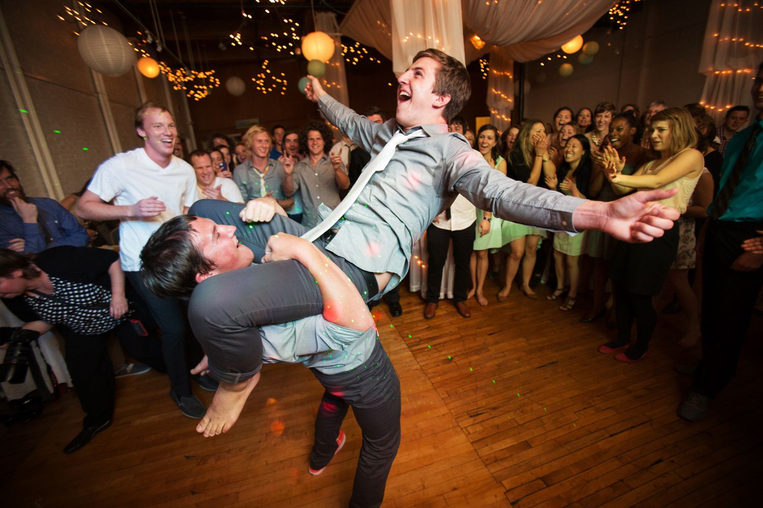groom riding a groomsmen on the dance floor