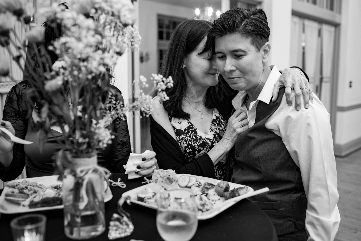 Black and white photo showing couples dancing together at an elegant indoor celebration.