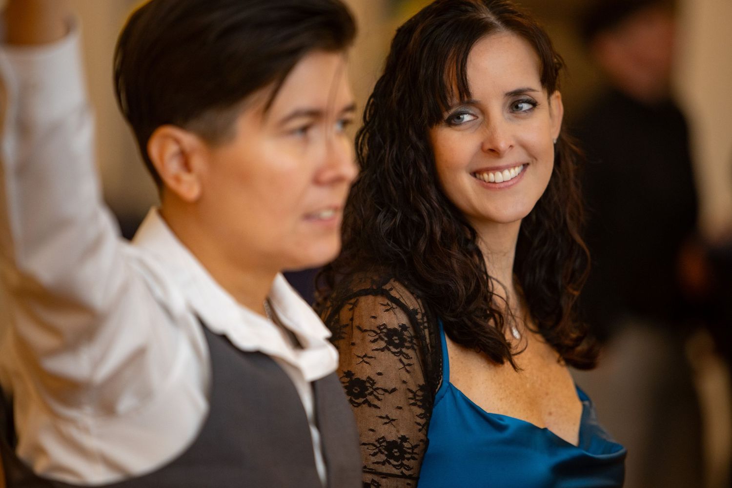 Festive indoor celebration with people wearing formal attire in an elegantly lit room.