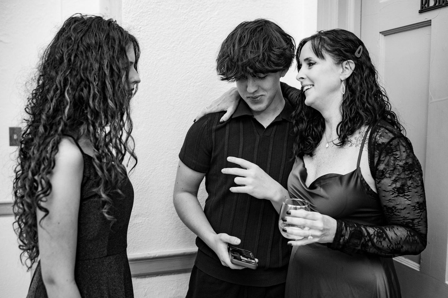Four black and white photos show two people in casual clothing looking at mobile phones together.