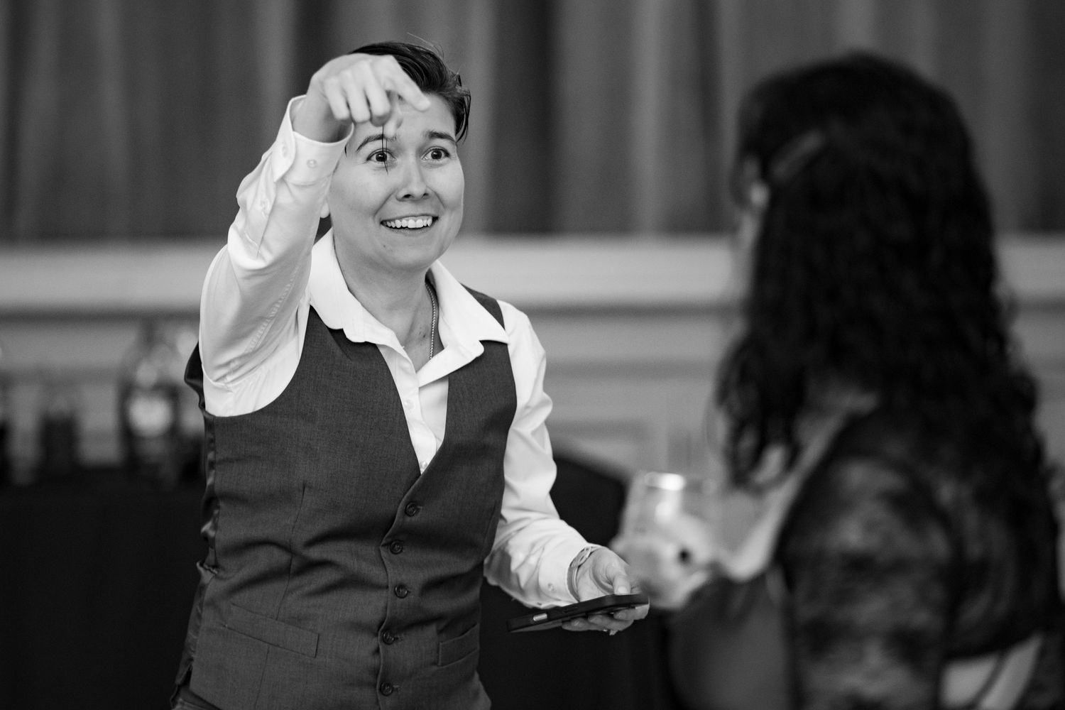 Joyful guests sharing laughter and conversation during formal dinner celebration.