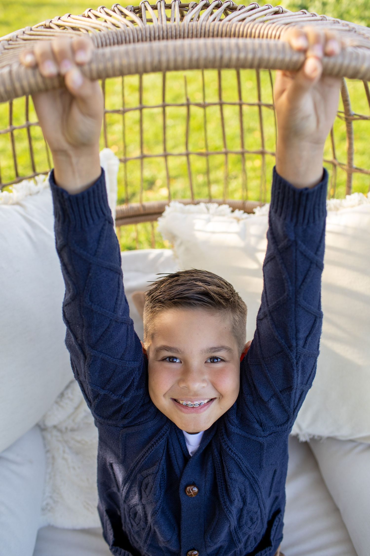Sequence of images showing someone in a navy blue sweater hanging and playing on outdoor monkey bars.