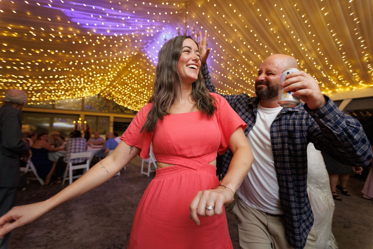 Wedding guests dancing under a canopy of twinkling string lights creating a magical atmosphere.